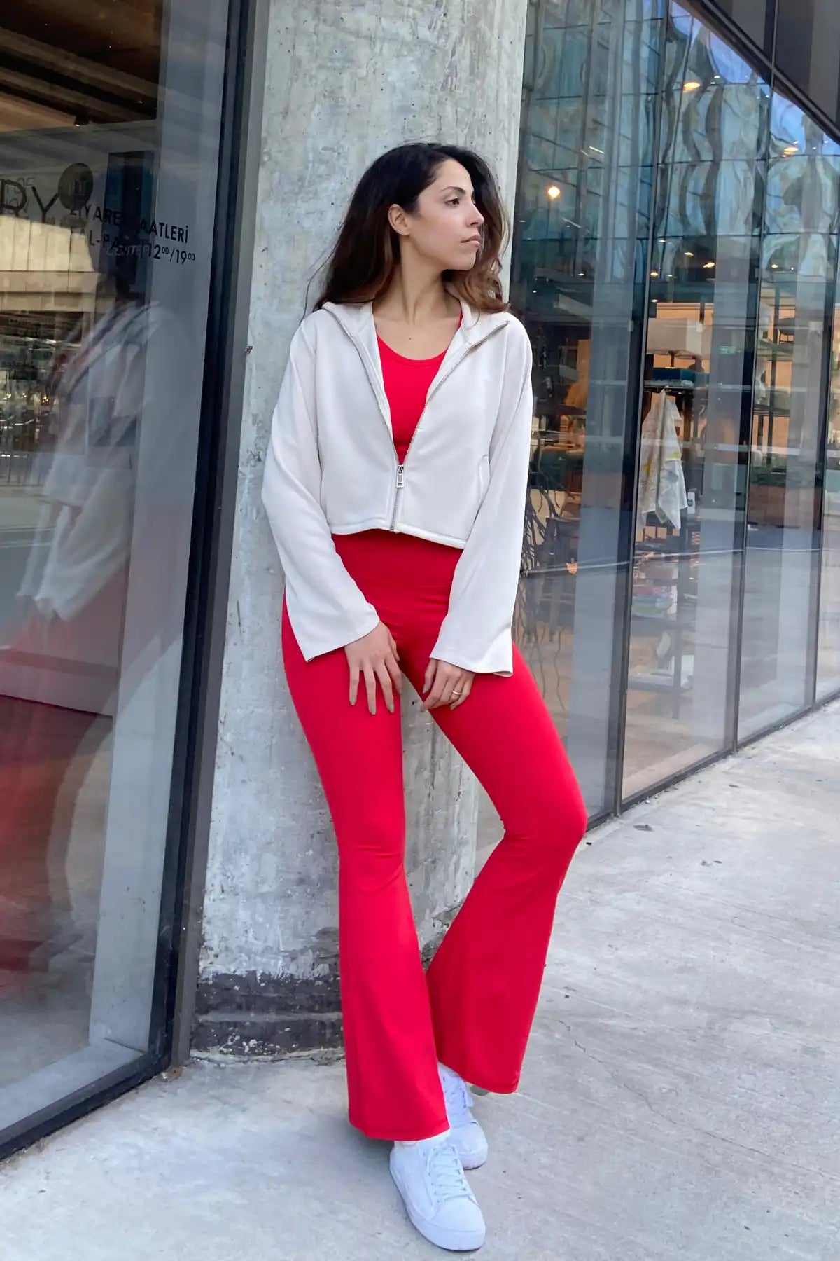 Beyaz ceket giymiş kırmızı kıyafetli kadın.